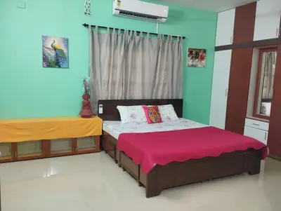 a bedroom with two beds and a window at SHI's Isha Homestay in Coimbatore in Coimbatore