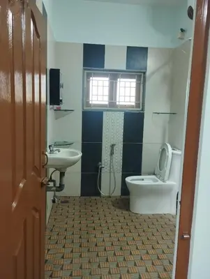 a bathroom with a toilet and a sink at SHI's Isha Homestay in Coimbatore in Coimbatore