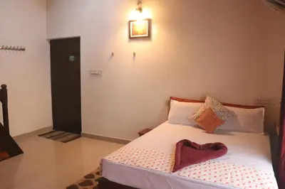 a bedroom with a bed with a heart pillow on it at Coorg Northbreeze Estate stay in Madikeri