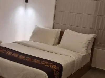 a bed with white sheets and pillows in a room at Leaves Resort Vythiri Wayanad in Vythiri