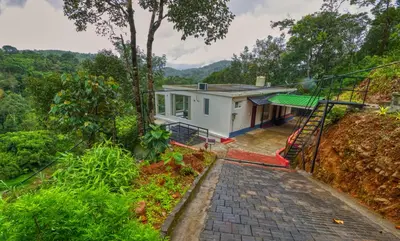 a house on a hill with a staircase leading up to it at Ende Wayanad Resort in Koroth