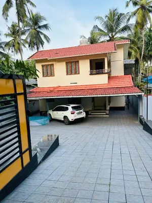 a car parked in a parking lot in front of a house at Saaketh Holiday Home(2) in Kozhikode