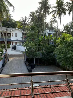 a view from a balcony of a house with palm trees at Saaketh Holiday Home(2) in Kozhikode