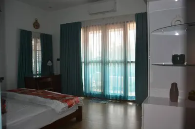 a bedroom with a bed and a large window with green curtains at Earth - Luxurious 5 BHK AC Villa at Mysore in Mysore
