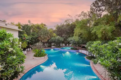 an image of a swimming pool in a yard with trees at Club Mahindra Golden Landmark, Mysuru in Mysore