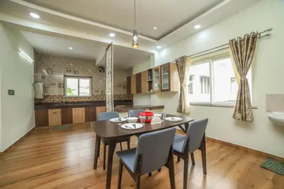 a kitchen and dining room with a table and chairs at AVJ Nest, Kodaikanal in Kodaikānāl