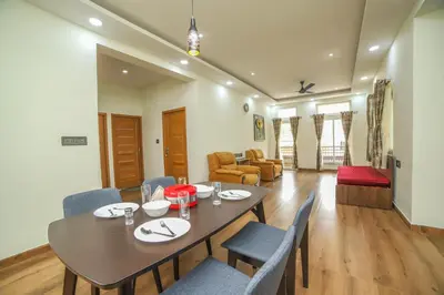a dining room with a table and chairs at AVJ Nest, Kodaikanal in Kodaikānāl