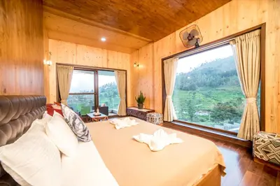 a bedroom with a bed and a large window at Sri Vidhya Residency by Indo Stays in Kotagiri