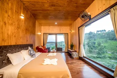 a bedroom with a large bed with a large window at Sri Vidhya Residency by Indo Stays in Kotagiri