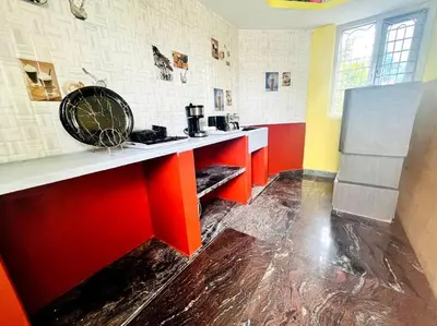 a kitchen with red and white counters and a refrigerator at Chamundi_Temple-Hill View. in Mysore