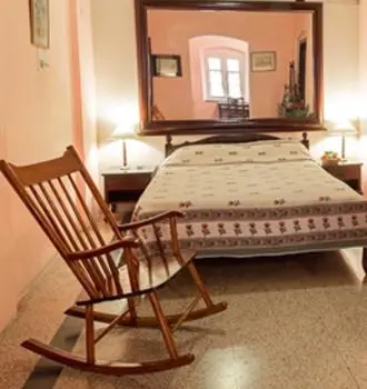 a chair and a bed in a room with a mirror at The Green Hotel in Mysore