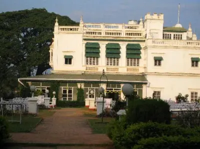 a large white building with green shutters on it at The Green Hotel in Mysore