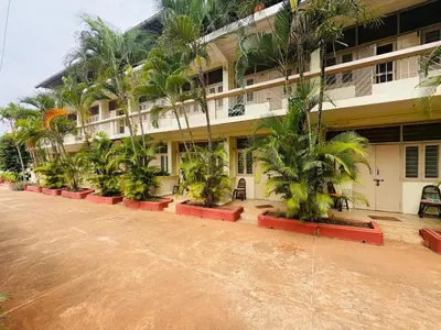a building with palm trees in front of it at The Green Hotel in Mysore