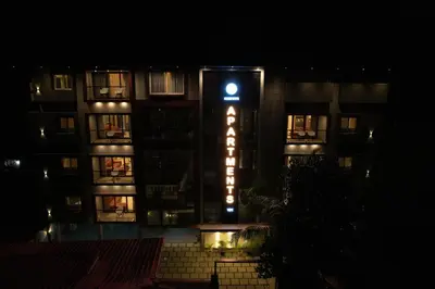a building with a hotel sign at night at Ncomforts Luxurious Apartments in Perintalmanna
