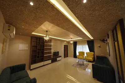 a living room with two couches and two chairs at Ncomforts Luxurious Apartments in Perintalmanna