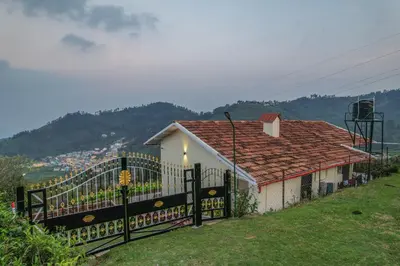 a house with a black gate and a mountain at The Springs by Indo Stays in Yedapalli
