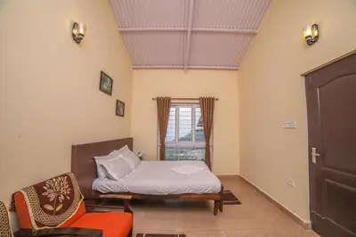 a bedroom with a bed and a chair and a window at The Springs by Indo Stays in Yedapalli