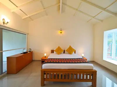 a bedroom with a bed and a large window at Ibex Resorts, Kotagiri in Kotagiri