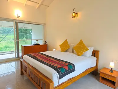 a bedroom with a large bed with a large window at Ibex Resorts, Kotagiri in Kotagiri