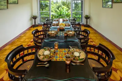 a dining room with a long table with plates of food at ama Stays & Trails Anjanagiri , Kotagiri in Kotagiri