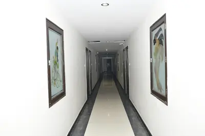 a corridor in a building with paintings on the walls at Nijaguna Resorts in Chāmrājnagar