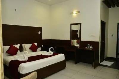 a hotel room with two beds and a mirror at Nijaguna Resorts in Chāmrājnagar