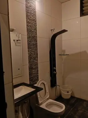 a small bathroom with a toilet and a sink at Nijaguna Resorts in Chāmrājnagar