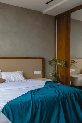 a bedroom with a bed with a blue blanket on it at Royal Holidays & Stays in Pattāmbi