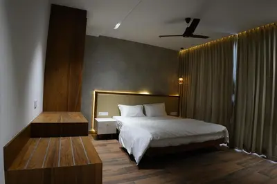 a bedroom with a bed and a ceiling fan at Royal Holidays & Stays in Pattāmbi