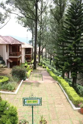 a garden with a sign in the middle of a path at KTDC Tea county in Munnar