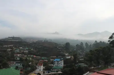 a view of a city with clouds in the sky at KTDC Tea county in Munnar