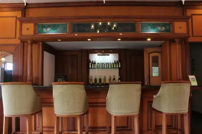 a bar with five chairs in front of it at KTDC Tea county in Munnar