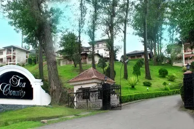 a gate with a sign in front of a house at KTDC Tea county in Munnar