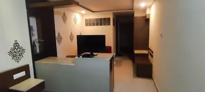 a room with a desk and a television in a room at Happy Vibes studio flats - service apartment in Mysore