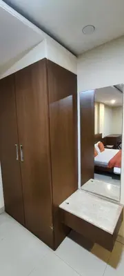 a room with a closet and a bed and a mirror at Happy Vibes studio flats - service apartment in Mysore