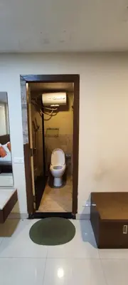 a bathroom with a toilet in a room at Happy Vibes studio flats - service apartment in Mysore