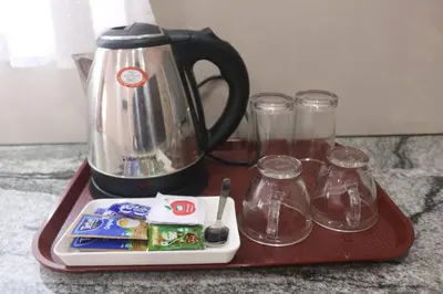 a tray with a coffee pot and glasses on it at Hotel Wayanad Stay in Kalpetta