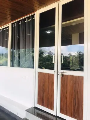 a pair of glass doors on a house at High shine Homestay in Meppādi