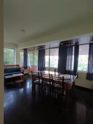 a living room with a table and chairs and a couch at High shine Homestay in Meppādi
