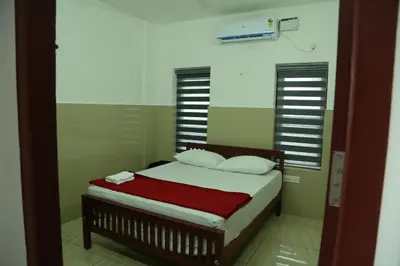 a bedroom with a bed with a red blanket at Grace Mary Residency in Nedumbassery