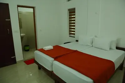 a bedroom with a large bed with a red blanket at Grace Mary Residency in Nedumbassery