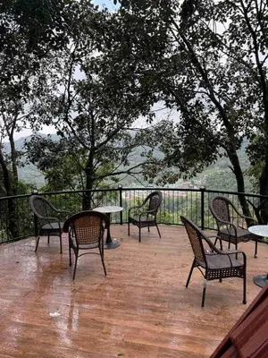 a group of chairs and tables on a deck at Boulevard Resorts in Kakkadampoyil