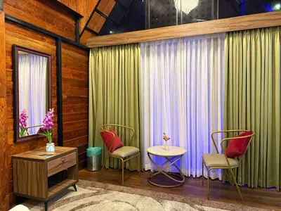 a room with two chairs and a table and a window at Boulevard Resorts in Kakkadampoyil
