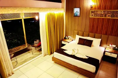 a bedroom with a large bed and a balcony at Boulevard Resorts in Kakkadampoyil