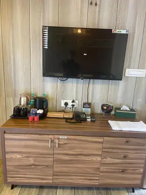 a wooden dresser with a television on top of it at Boulevard Resorts in Kakkadampoyil