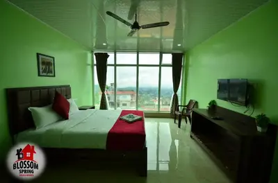a bedroom with a bed and a large window at Blossom Spring Villa in Ooty