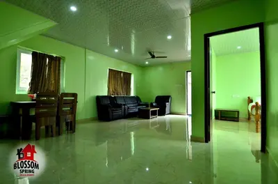a living room with green walls and leather furniture at Blossom Spring Villa in Ooty
