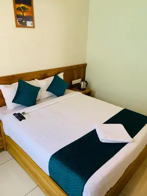 a bedroom with a large white bed with blue pillows at Regalia Wayanad in Kalpetta