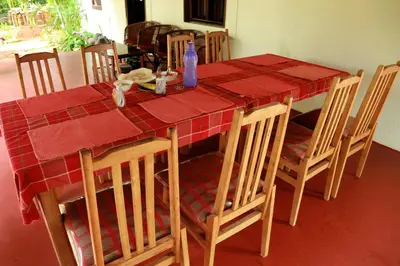 a dining room table with a red table cloth and chairs at Ocean Green Kerala in Kannur