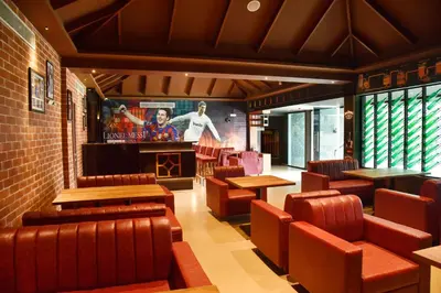 a restaurant with brown leather chairs and a tv at THE PEARL VIEW HOTEL in Mulappilangād